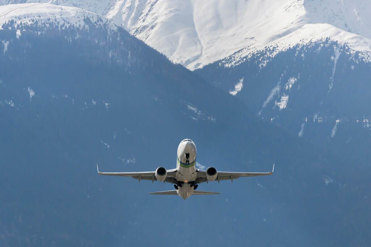 aereo che decolla con dietro montagna